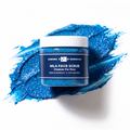 Zawina Morocco Nila Face Scrub jar resting over a textured swatch of vibrant blue exfoliating face cleanser paste