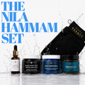 Zawina Morocco The Nila Hammam Set graphic featuring Organic Argan Oil, Black Soap with Argan and Rose, Nila Sabounia, Tebrima Body Mask, and a black Kessa glove in splashing water