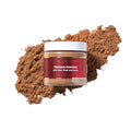 Zawina Morocco Tebrima Powder with Aker Fassi and herbs jar resting over a swatch of fine brown herbal powder